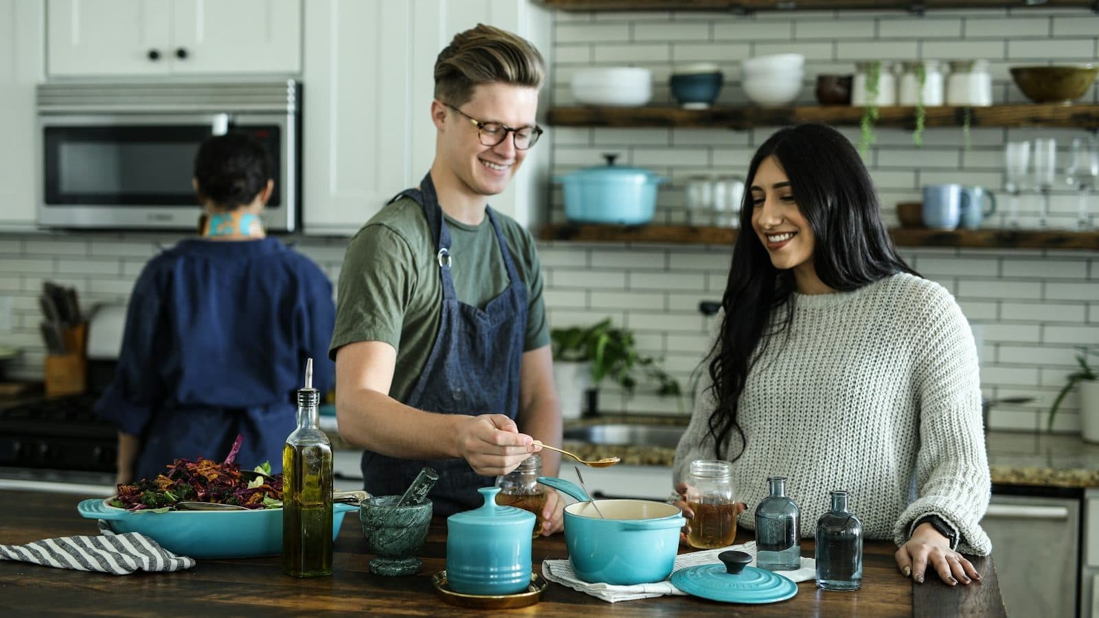 smiling man standing and mixing near woman in kitchen area of the house